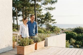 Couple devant leur maison moderne adaptée à leur quotidien à Royan avec terrasse et vue sur jardin