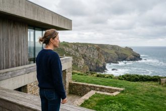 Femme d'âge moyen sur terrasse face à la côte bretonne
