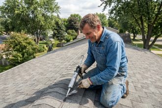 Couvreur homme en action sur le toit résidentiel